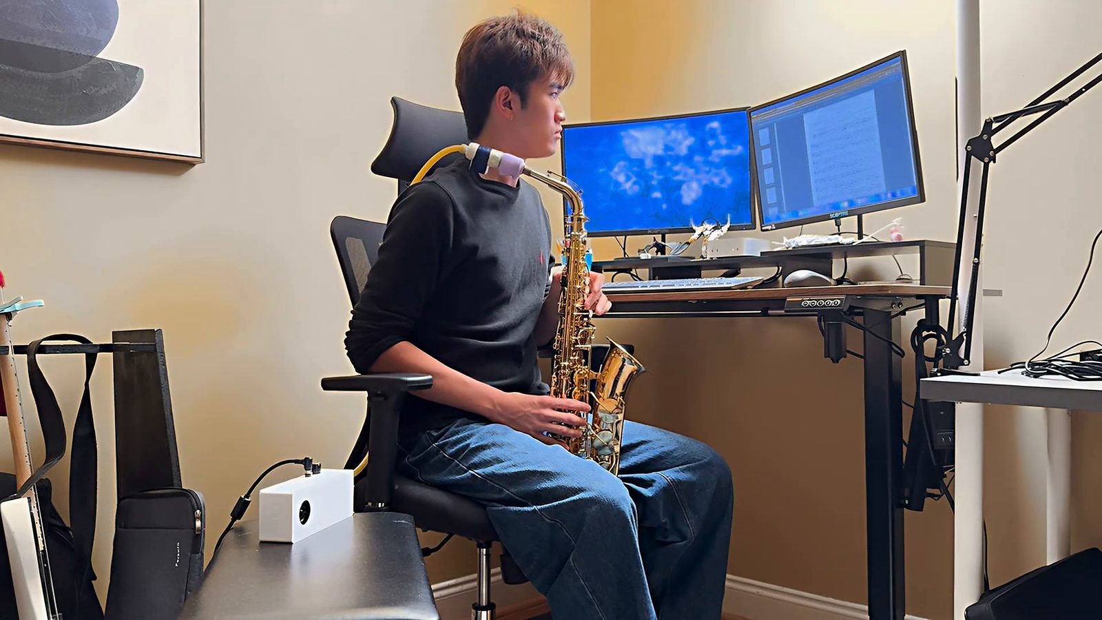 Ethan fingering a saxophone driven by the Mechanical Embouchure at his desk